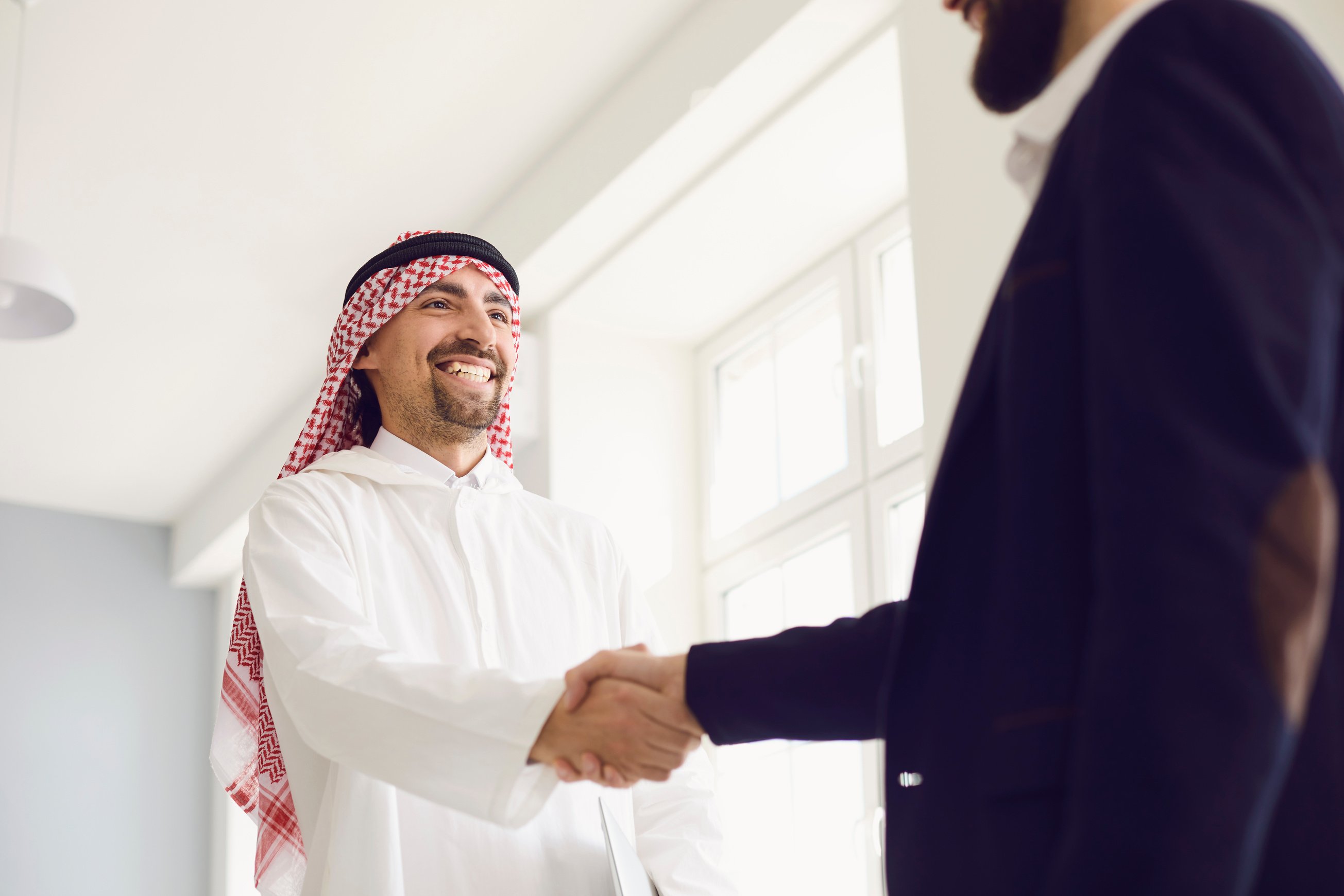 Handshake of Arabic and European Businesspeople in Office.